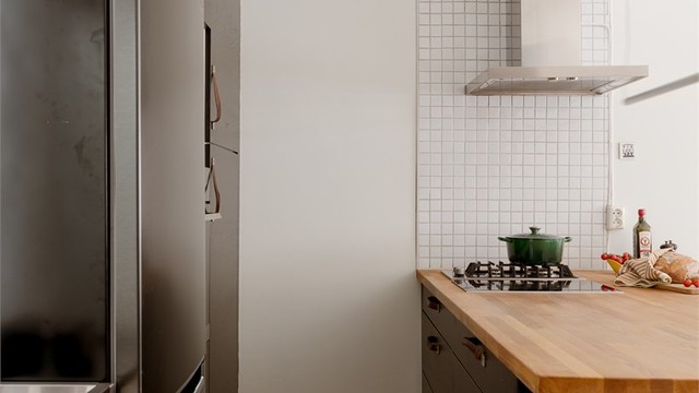 Hvitevarene består av nedfelt platetopp på kjøkkenøy, ventilator med kullfilter på vegg og integrert komfyr i høyskap. Opplegg for oppvaskmaskin under benkeplate og plass for frittstående kjøleskap.