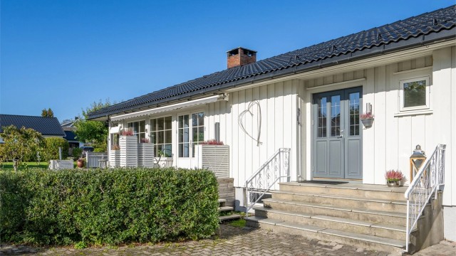 hyggelig inngangsparti med trapp og smijernsrekkverk.