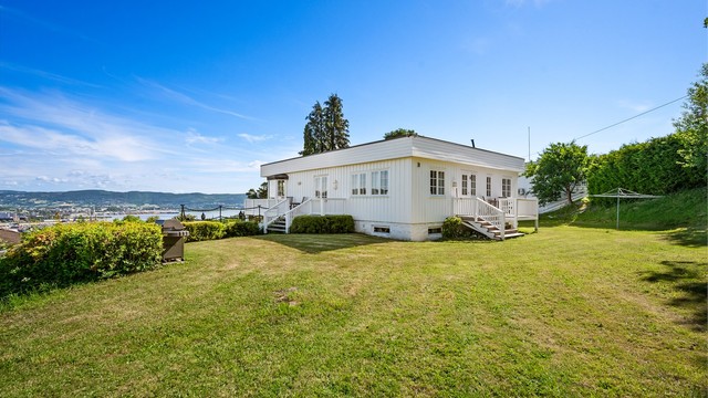 Tomten er opparbeidet med plen og beplantning.