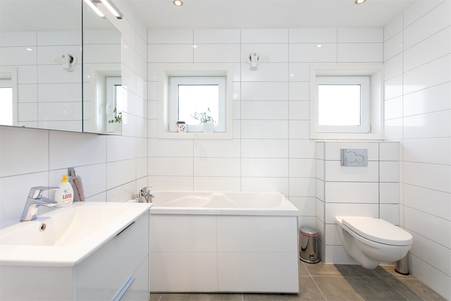 Badet i hovedetasjen fra 2016 med flislagt gulv med varmekabler, flislsagte vegger og malt tak.