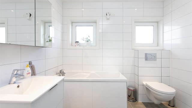 Badet i hovedetasjen fra 2016 med flislagt gulv med varmekabler, flislsagte vegger og malt tak.