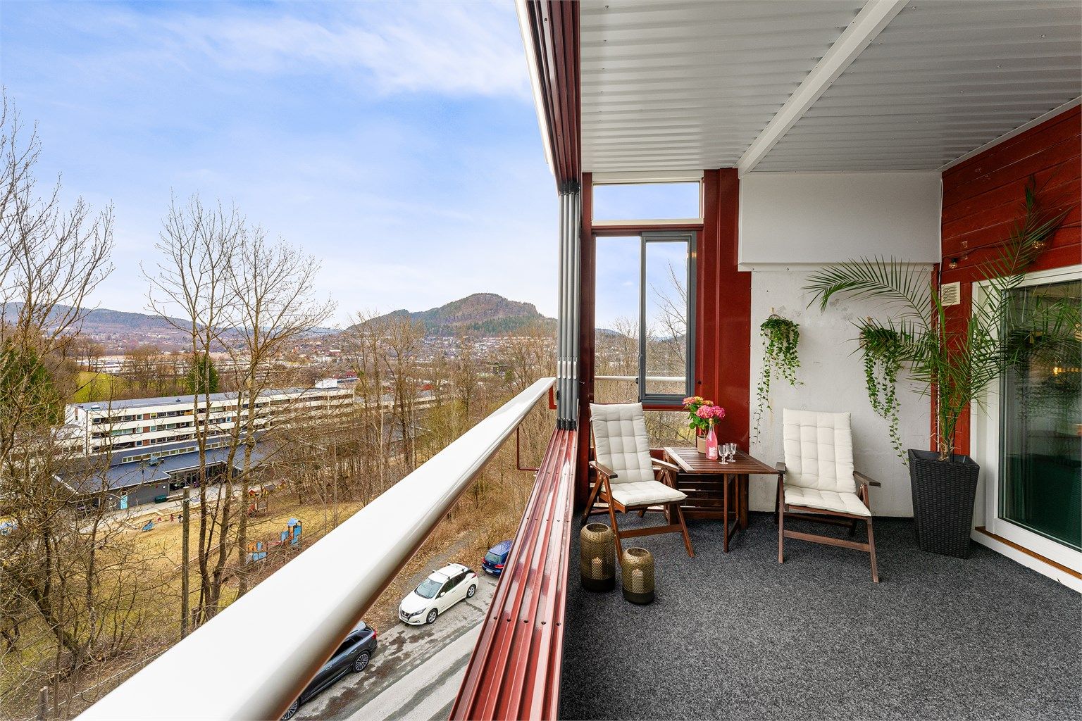 Utsikten fra balkongen strekker seg mot Kolsåstoppen og de grønne omgivelsene.