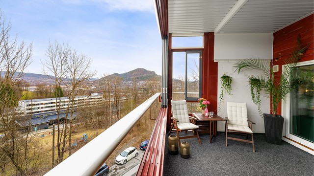 Utsikten fra balkongen strekker seg mot Kolsåstoppen og de grønne omgivelsene.