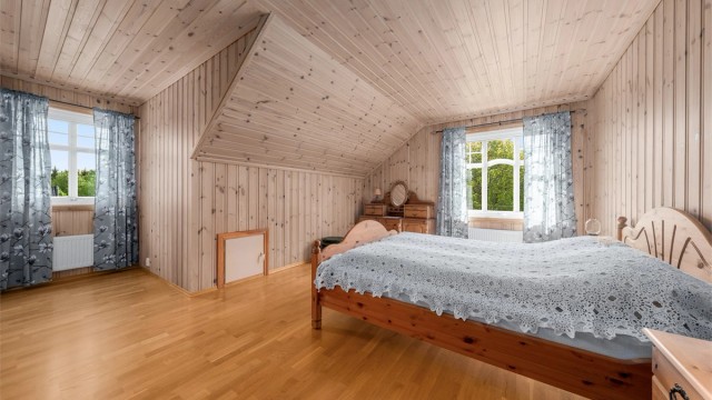 Det ene av to soverom i andre etasje. Rommet har parkettgulv og panelkledde vegger.