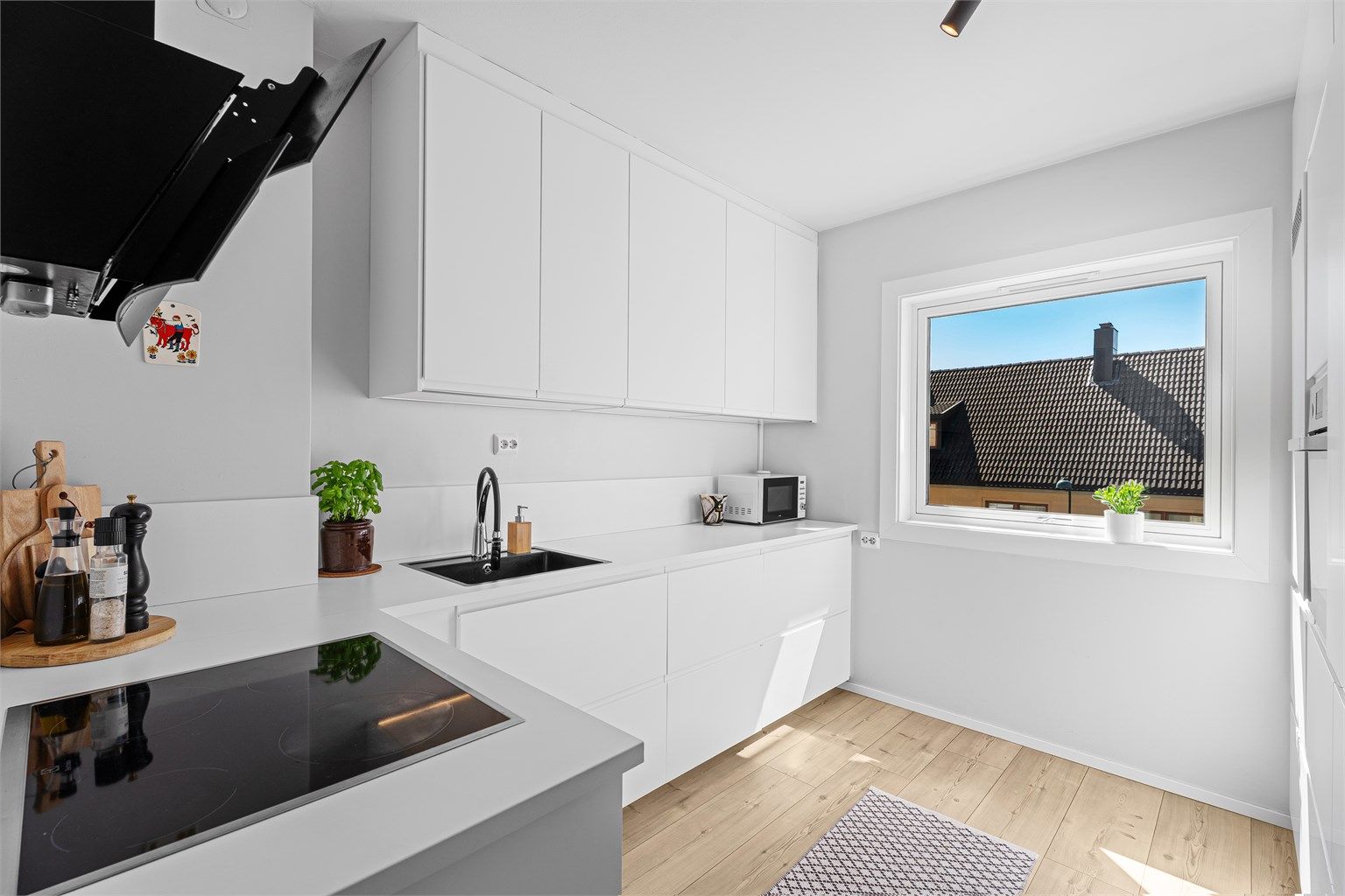 Lyst nyere kjøkken fra IKEA, med god benk- og skapplass.