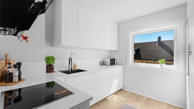 Lyst nyere kjøkken fra IKEA, med god benk- og skapplass.