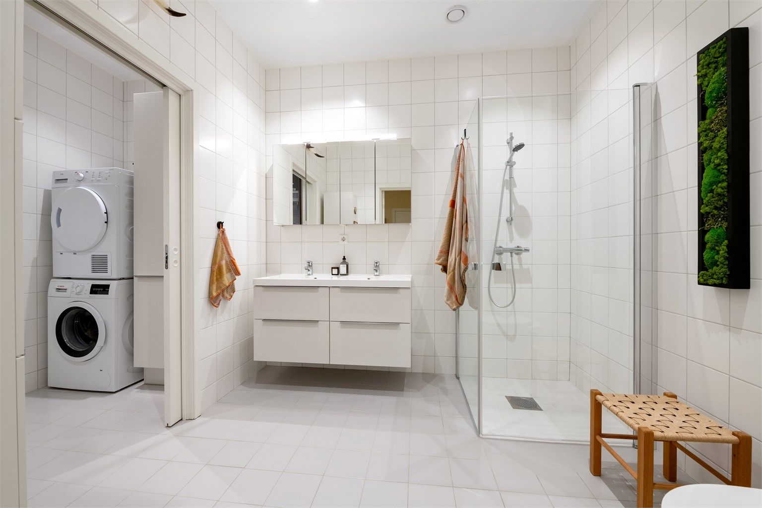 Badet har en praktisk vaskeromsdel med opplegg for vaskemaskin og tørketrommel.