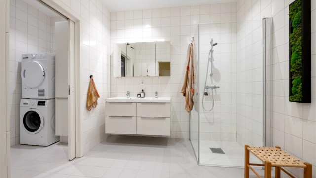 Badet har en praktisk vaskeromsdel med opplegg for vaskemaskin og tørketrommel.