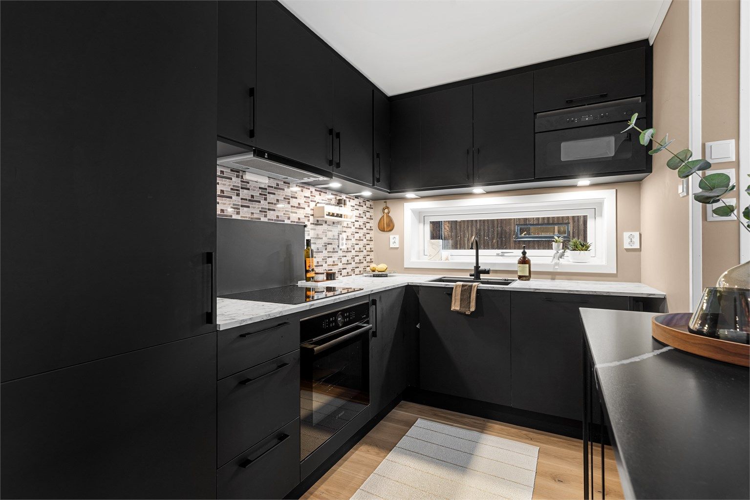 Kjøleskap med fryser, oppvaskmaskin, stekeovn, mikrobølgeovn og platetopp. Vegghengt ventilator. Komfyrvakt tilkoblet platetopp.