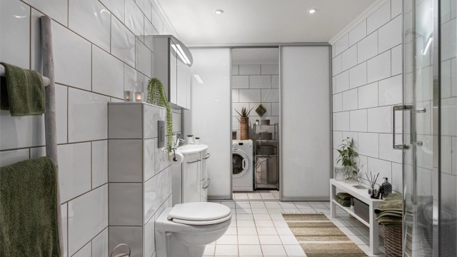 Egen vaskeromsavdeling bak skyvedører (2017), med opplegg for vaskemaskin og ekstra sluk.