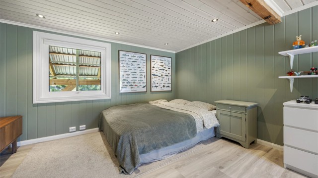 Rommet har panel på vegger og i tak, med downlights.