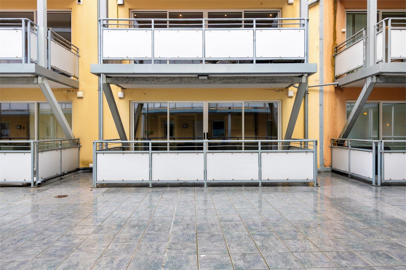 Balkongen er sørvendt og vender inn mot byggets skjermede atrium, noe som skaper en lun og trivelig uteplass.