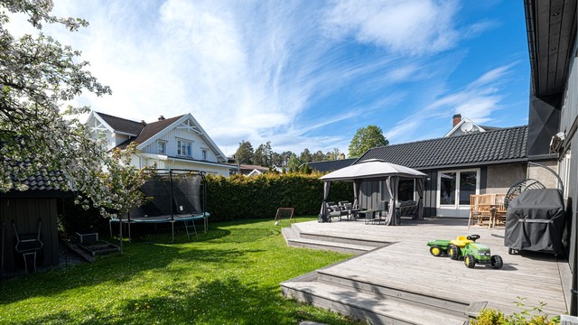 Fra stue er det utgang til solrik og stor uteplass med hage