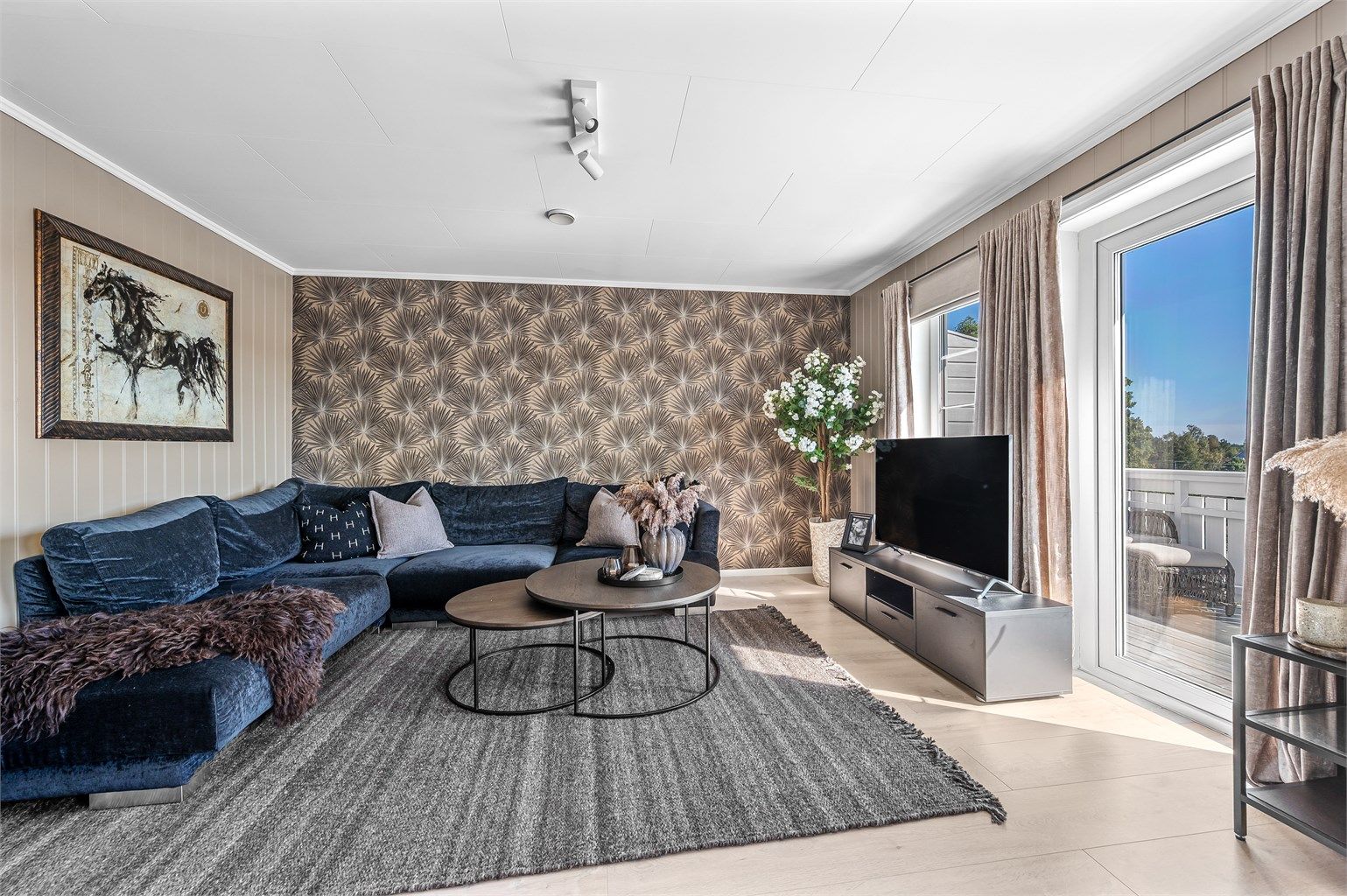 Stuen har god plass til en romslig sofagruppe og utgang til balkongen.