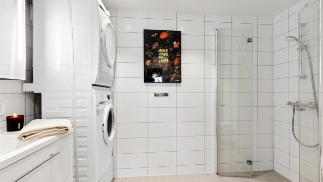 Moderne og romslig baderom med flislagt gulv med varme, downlights og opplegg for vaskemaskin. Varmtvann er inkludert i felleskostnadene.