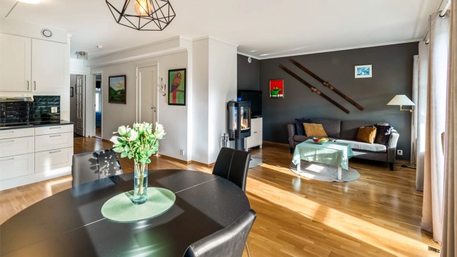 Åpen og romslig planløsning mellom kjøkken, spiseplass og sofakrok.