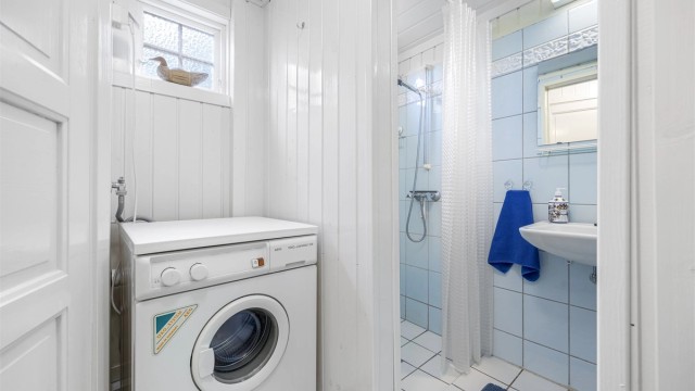 Badet er praktisk innredet med dusjnisje og opplegg for vaskemaskin.