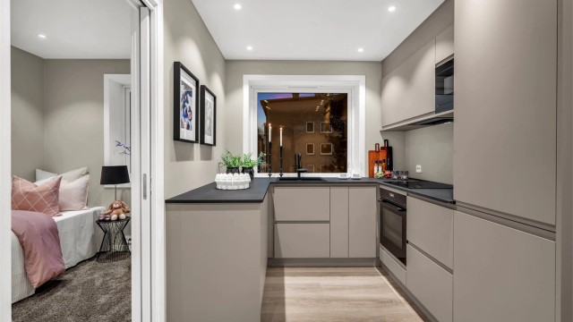 Fra kjøkkenet er det enkel adkomst til to av leilighetens tre soverom.