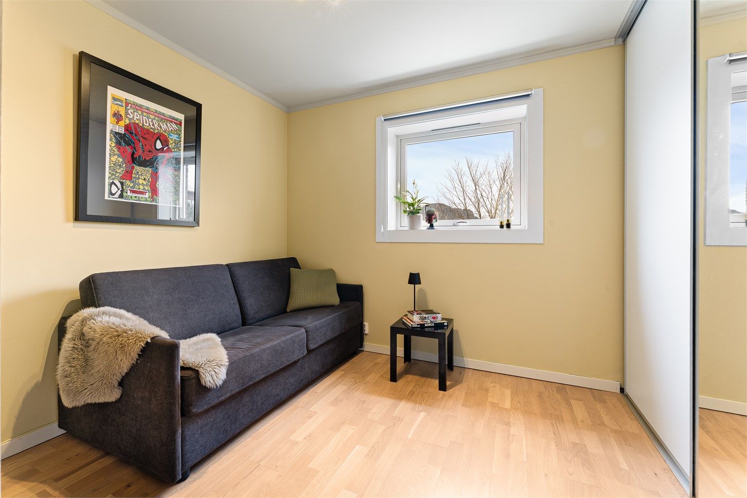 Leilighetens andre soverom er også utstyrt med en praktisk skyvedørsgarderobe.