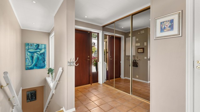 Romslig entré/hall med gulvvarme og skyvedørsgarderobe med god plass til yttertøy