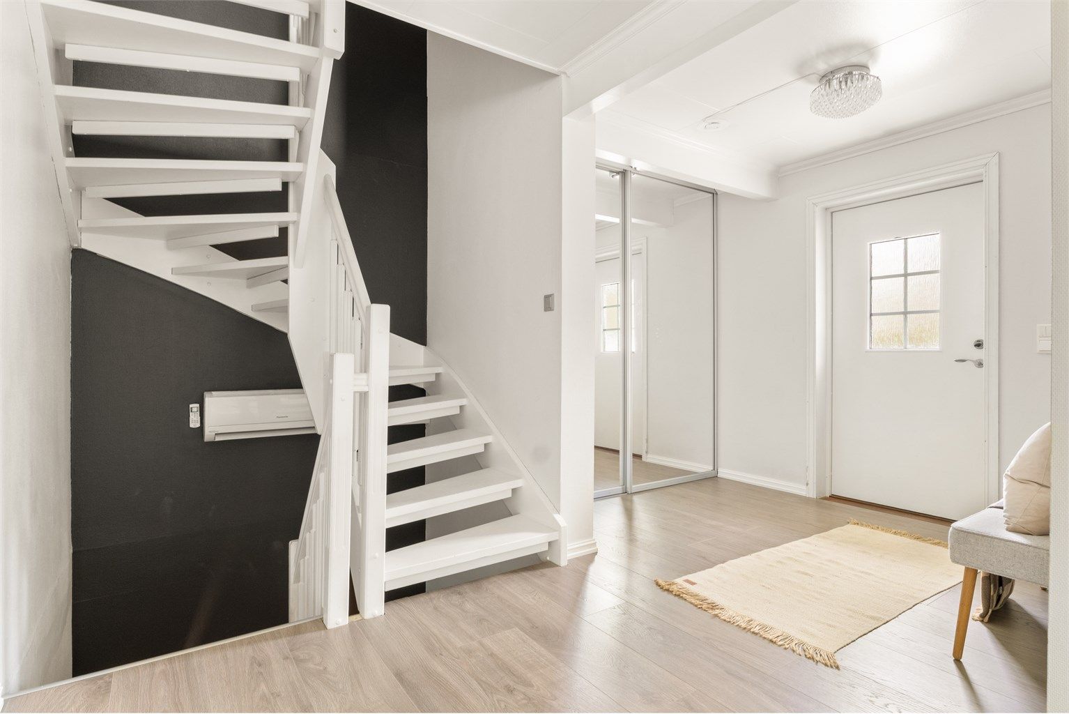 Romslig entré med skyvedørsgarderobe for effektiv oppbevaring av yttertøy og sko.