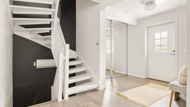 Romslig entré med skyvedørsgarderobe for effektiv oppbevaring av yttertøy og sko.