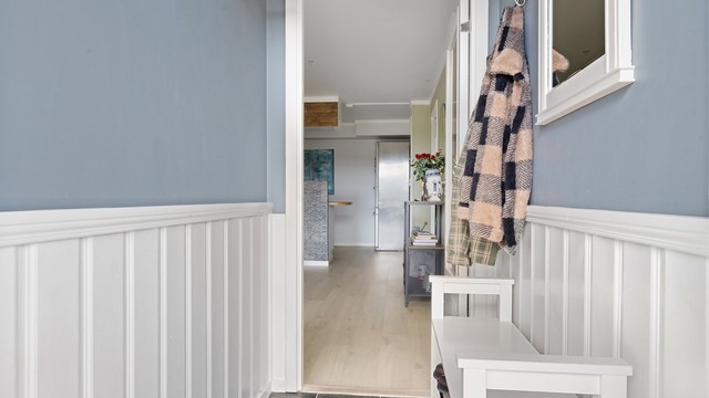 Fra vindfanget ledes du videre inn i leilighetens åpne stue- og kjøkkenløsning.