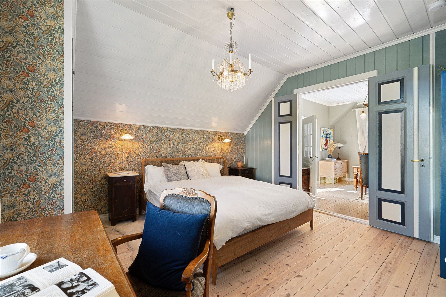 Hovedsoverommet fremstår svært innbydende, med harmoniske og behagelige fargetoner. Originale doble fløydører og tapet fra William Morris 