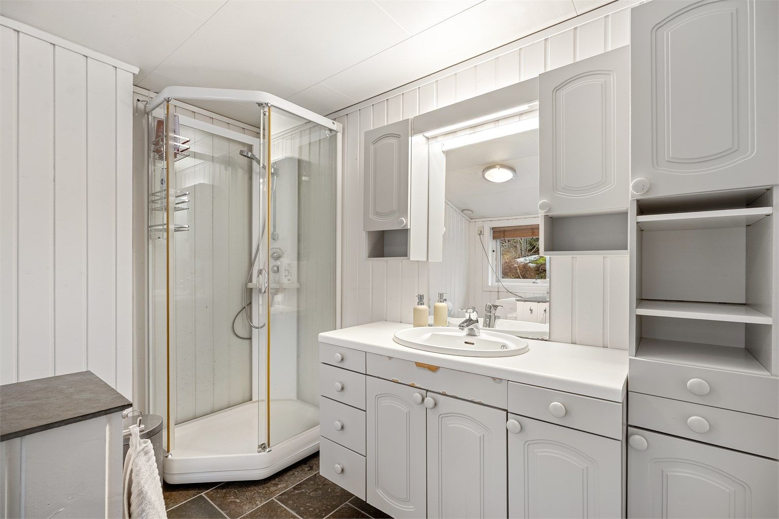 Bad med mye lagringsplass og dusjkabinett.