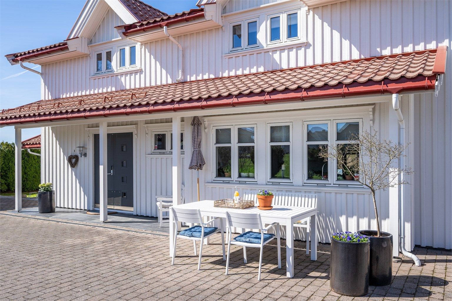 En hyggelig uteplass ved inngangspartiet, med belegningsstein på gårdsplassen.