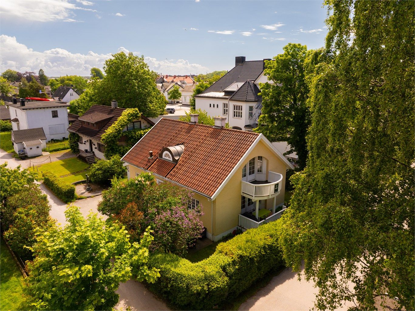 En avskjermet og pent innrammet hage omgir boligen som til tross for sin nyklassisistisk inspirerte fasade faktisk er den yngste i omgivelsene.