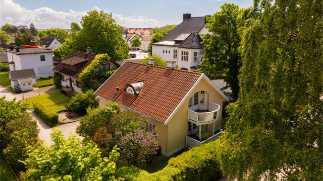 En avskjermet og pent innrammet hage omgir boligen som til tross for sin nyklassisistisk inspirerte fasade faktisk er den yngste i omgivelsene.