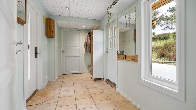Entré med adkomst til gårdsplassen og til terrasseplatting på baksiden av boligen