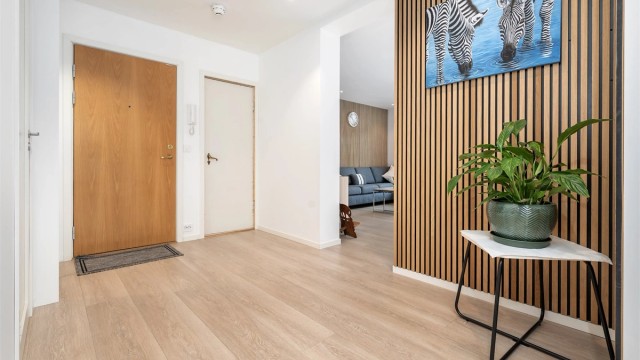 Velkommen inn i en lys entré som leder deg videre til leilighetens øvrige rom.