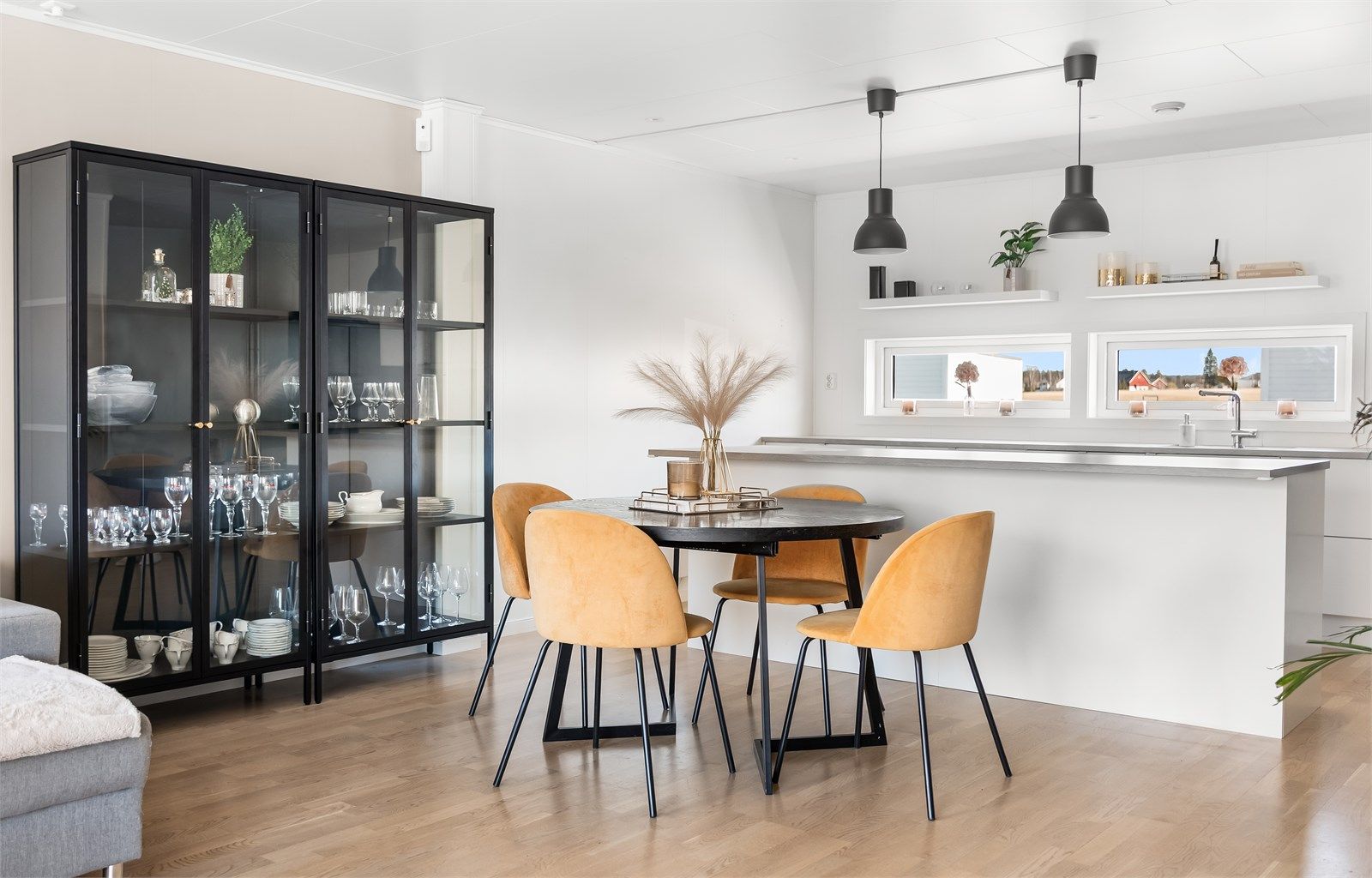 Den åpne løsningen gir en naturlig flyt mellom kjøkkenet og en romslig spiseplass.