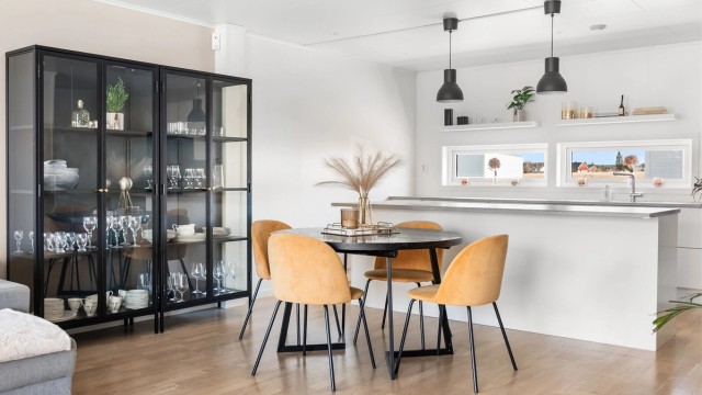Den åpne løsningen gir en naturlig flyt mellom kjøkkenet og en romslig spiseplass.