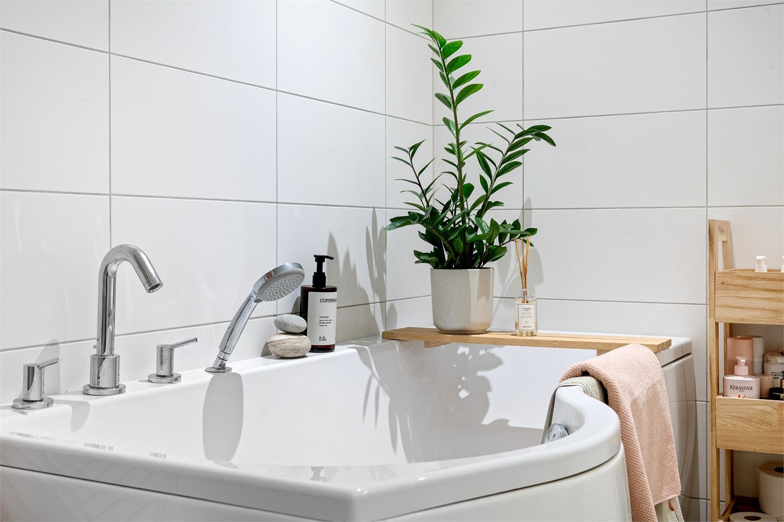 Baderommet har veggmontert toalett og en hel servantplate med underskap.