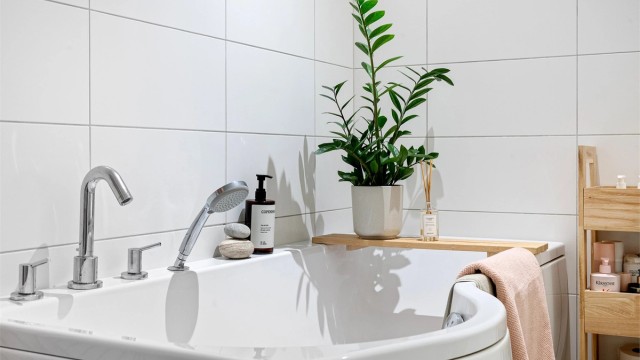 Baderommet har veggmontert toalett og en hel servantplate med underskap.