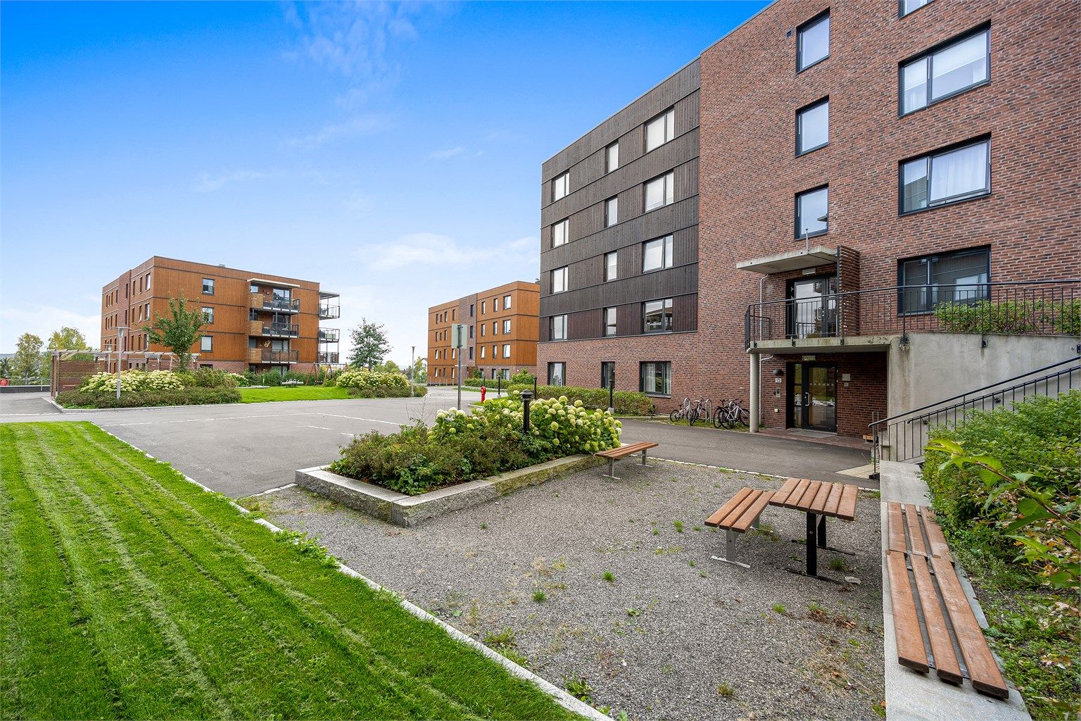 Åslia Boligsameie har velholdte uteområder med felles benker og grøntarealer.