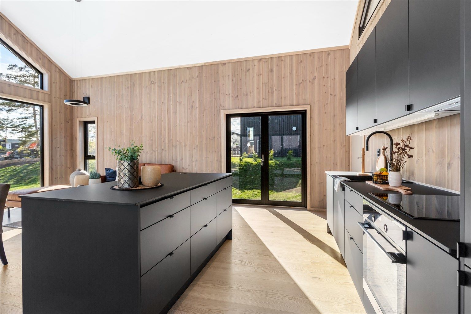 Kjøkkenet  er praktisk og står fint til de panelte veggene, samtidig som det tøffer opp stilen litt med de matte og slette flatene. Kjøkkenøya lager et fint skille i rommet.