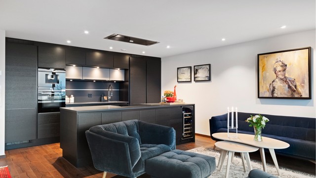 Flott påkostet kjøkkeninnredning fra HTH med mørke glatte fronter og benkeplate av Corian