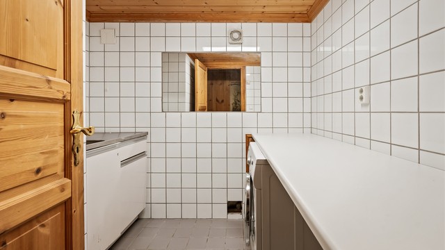 Separat vaskerom med flislagt gulv, gulvvarme og opplegg for vaskemaskin.