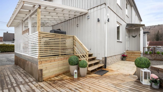 Overbygget inngangsparti med adkomst via en platting i tre.