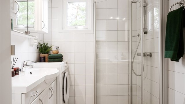 Delikat og funksjonelt bad med flislagte overflater og behagelig gulvvarme. Badet har vegghengt toalett, dusjhjørne med innfellbare glassdører og romslig servantskap med god oppbevaringsplass