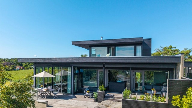 Stor tomt beliggende på en liten høyde. Boligen er bygget på fjell med flott utsikt over omkringliggende omgivelser og mot havet
