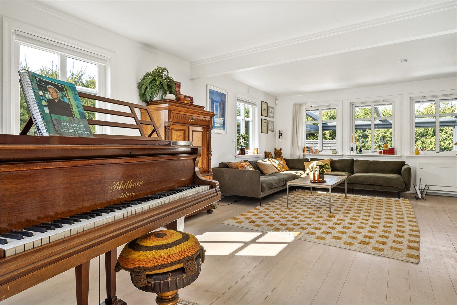 Stuen har en åpen og luftig atmosfære, med en etasjeskiller av lettbetongelementer som gir en solid følelse.