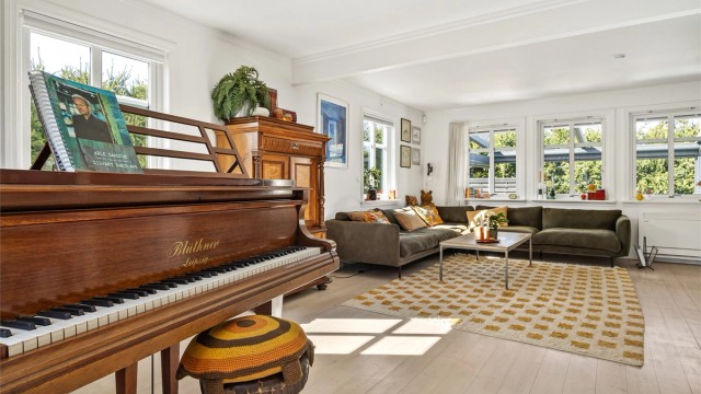 Stuen har en åpen og luftig atmosfære, med en etasjeskiller av lettbetongelementer som gir en solid følelse.