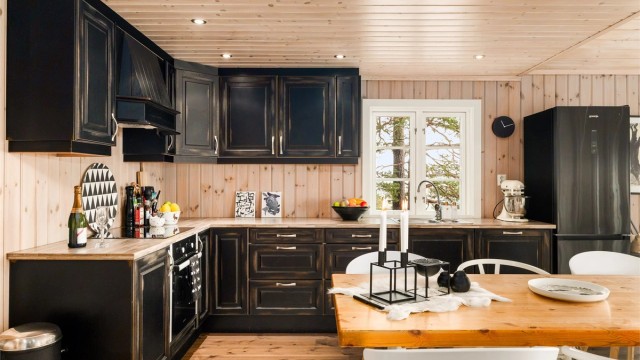 HELTRE: Kjøkkeninnredningen i heltre har en arbeidsvennlig L-form. Den har fått et strøk mørk brun, som kler de lyse panelveggene.
