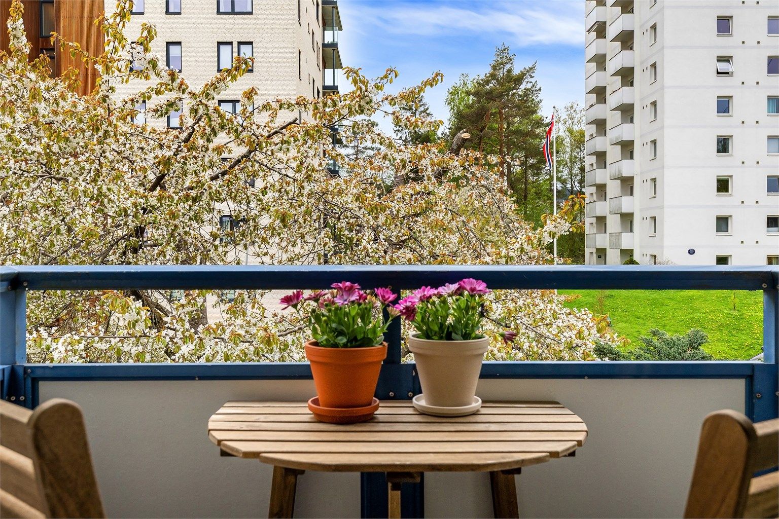 Den vestvendte balkongen har flislagt gulv og plass til en sittegruppe.