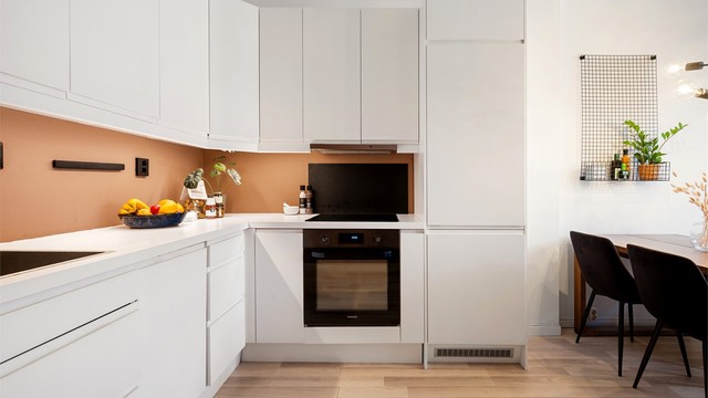 Videre er det plassert ventilator i overskap. Bak platetoppen/kjøkkenvasken er det montert en prakisk glassplate.